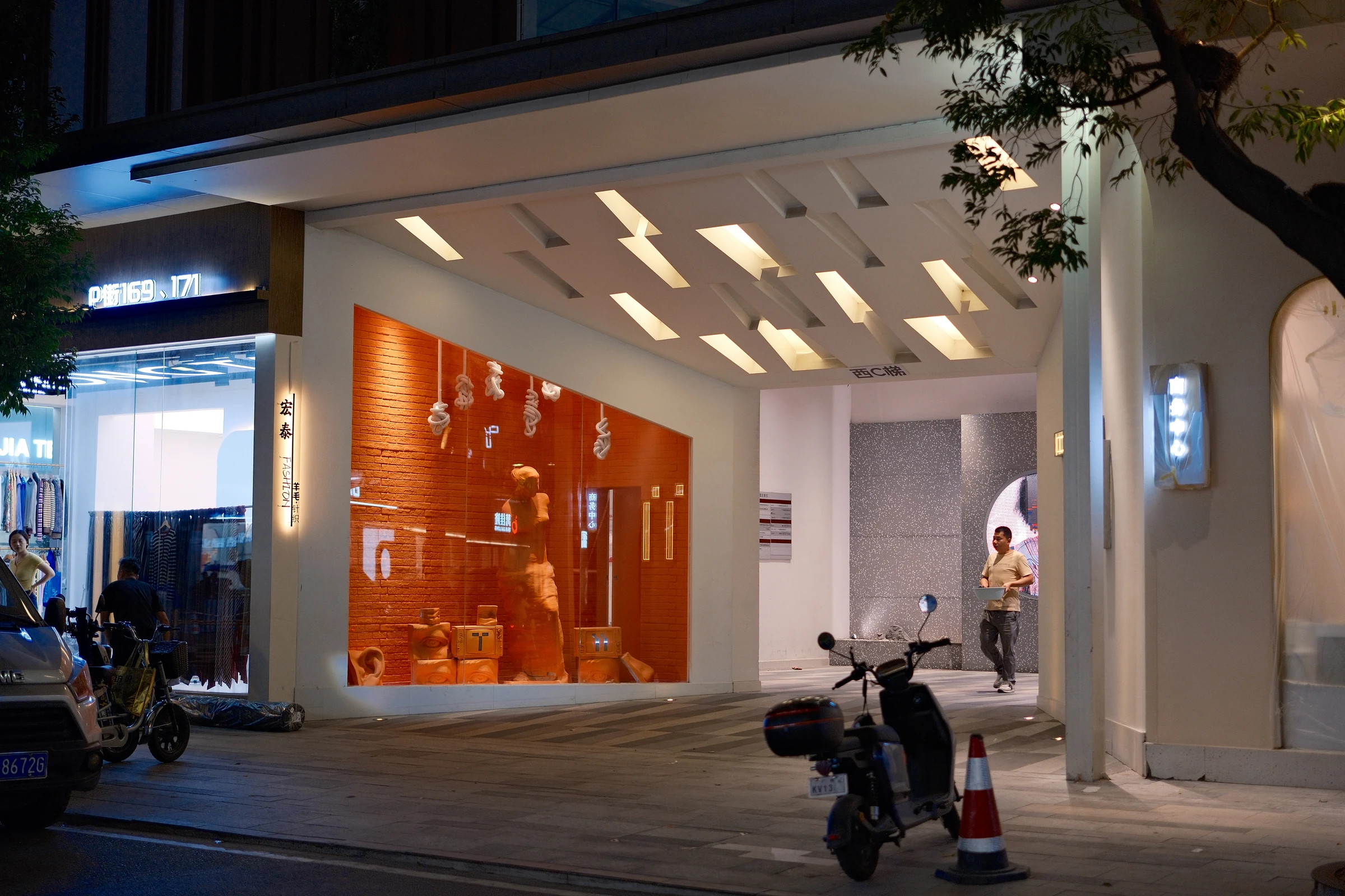夜色中由暖光照亮的商店入口与街边树影